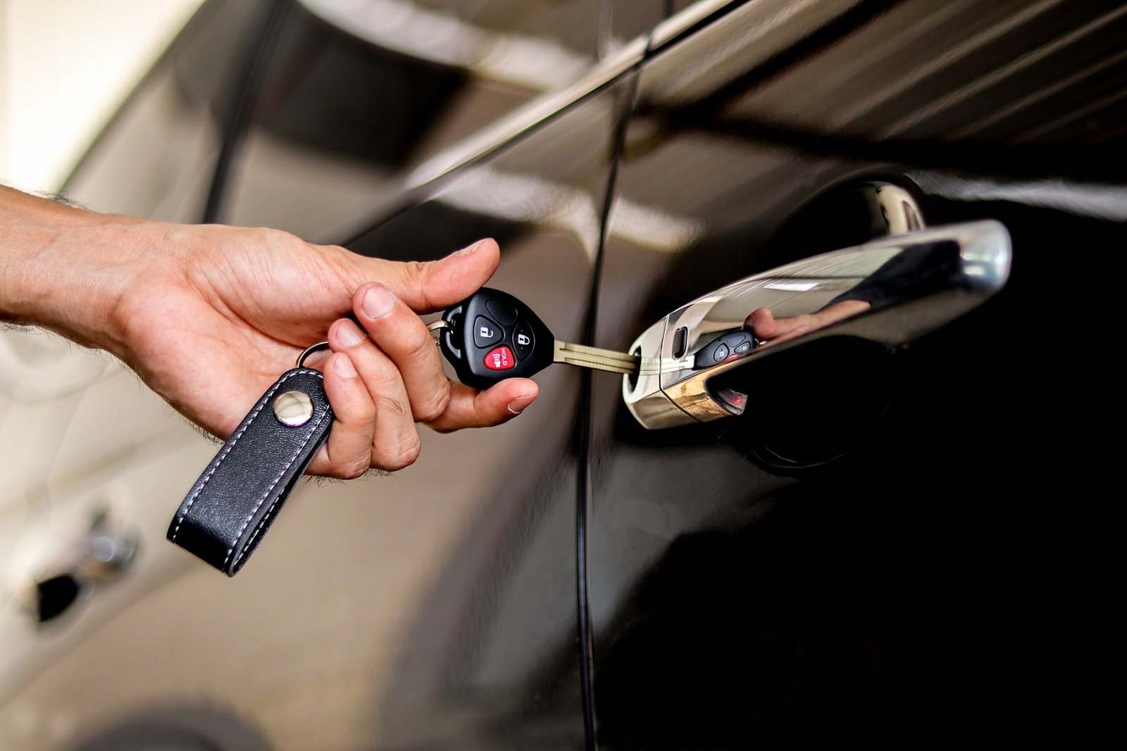 A man using a car key to open a car